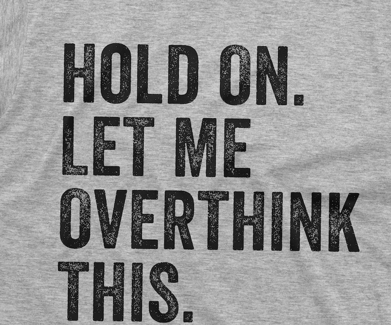 May include: Grey t-shirt with the text "HOLD ON. LET ME OVERTHINK THIS."