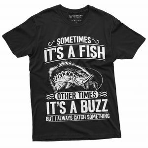 Pu&ograve; includere: T-shirt nera con un design grafico bianco di un pesce e il testo "Sometimes it's a fish, other times it's a buzz, but I always catch something."