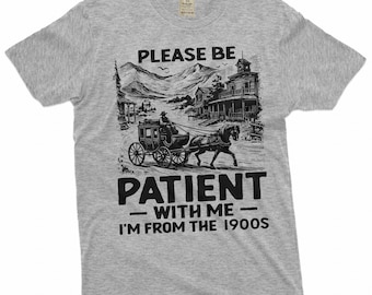 Könnte beinhalten: Graues T-Shirt mit einer schwarz-weißen Illustration einer Pferdekutsche und einer Westernstadt-Szene. Der Text "Please be patient with me - I'm from the 1900s" ist auf dem Shirt aufgedruckt.