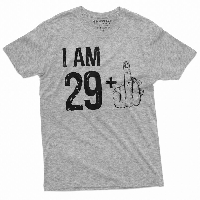 May include: A gray t-shirt with the text "I AM 29+" and a black and white illustration of a middle finger.