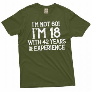 May include: A green t-shirt with white text that reads "I'm not 60! I'm 18 with 42 years of experience."