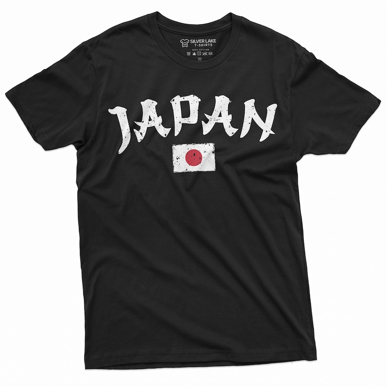 May include: Black t-shirt with a white distressed graphic of the word "JAPAN" in a stylized font. The graphic also includes the Japanese flag with a red circle on a white background.