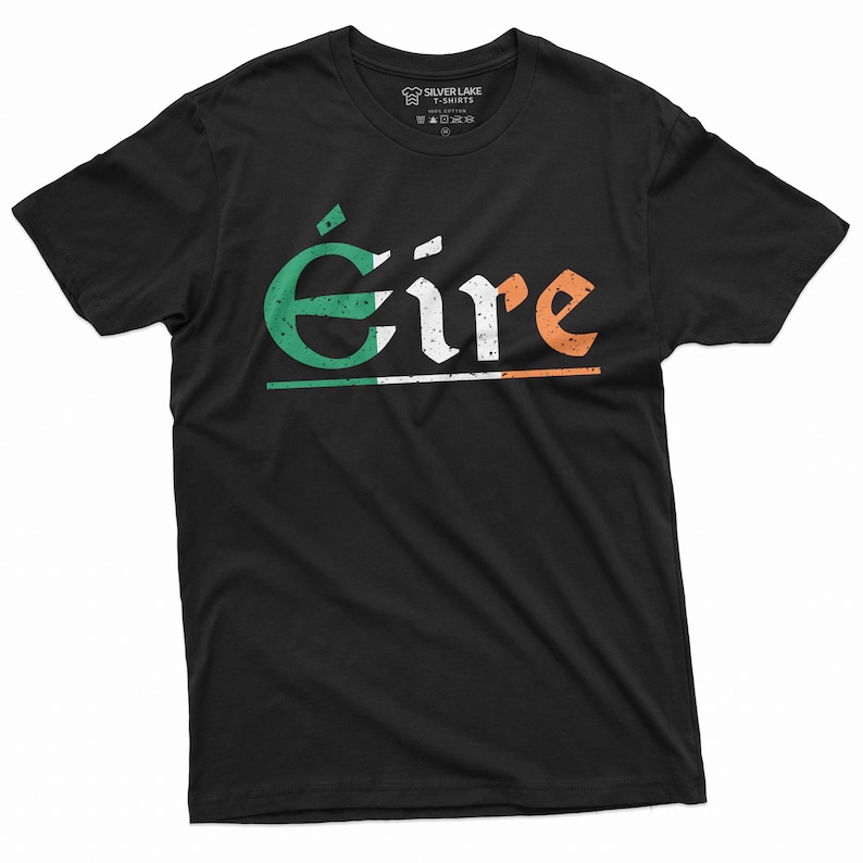 May include: Black t-shirt with a white, green, and orange graphic of the word "&Eacute;ire" in a vintage style font. The graphic includes a thin white line under the word and a faded Irish flag design.