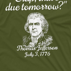 May include: A white graphic on a green t-shirt featuring a portrait of Thomas Jefferson with the text "Crap, that's due tomorrow?" and "July 3, 1776".