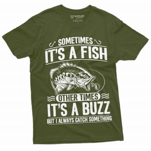 Pu&ograve; includere: Una maglietta verde con un design grafico bianco che dice "Sometimes it's a fish, other times it's a buzz, but I always catch something". Il grafico include anche un pesce con un amo in bocca.