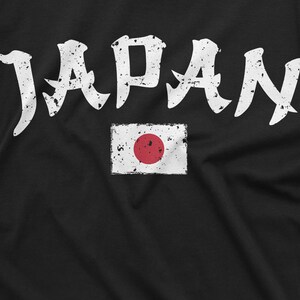 May include: Black t-shirt with white distressed lettering that says "JAPAN" and a white distressed image of the Japanese flag with a red circle in the center.
