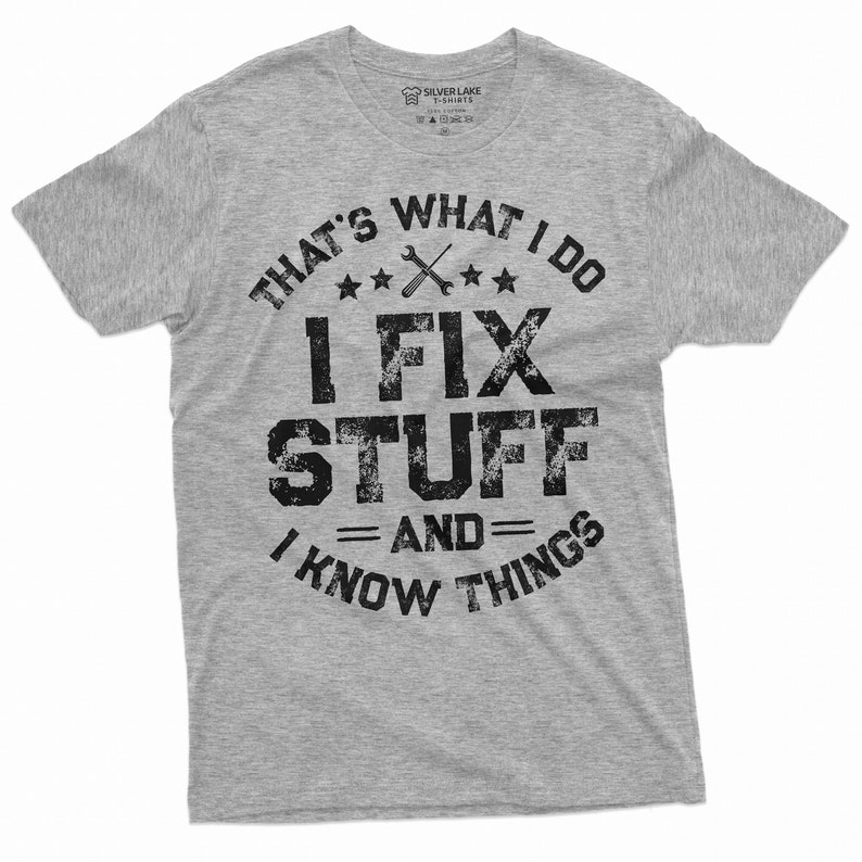 May include: A gray t-shirt with a distressed black graphic that reads "That's what I do I fix stuff and I know things". The graphic also includes a wrench and three stars.