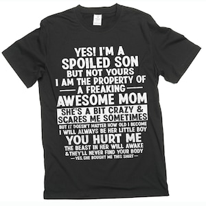 Może przedstawiać: Czarny t-shirt z białym tekstem. Tekst brzmi: "YES! I'M A SPOILED SON BUT NOT YOURS I AM THE PROPERTY OF - A FREAKING - AWESOME MOM...YOU HURT ME...YES, SHE BOUGHT ME THIS SHIRT-"