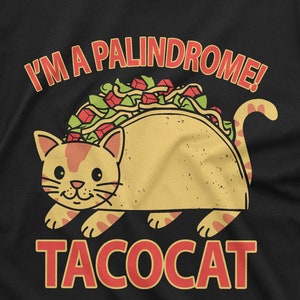 May include: A black t-shirt with a yellow and brown taco cat illustration. The text "I'm a palindrome!" is above the cat and the text "tacocat" is below the cat.
