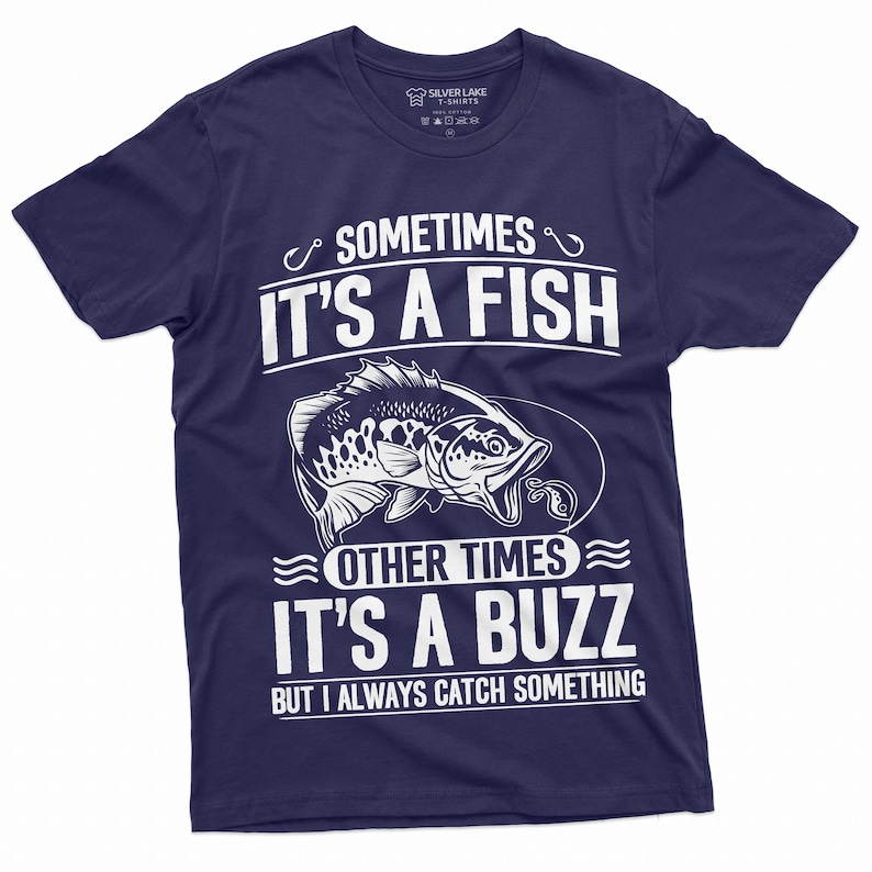 Pu&ograve; includere: Una t-shirt blu navy con una grafica bianca di un pesce e il testo "Sometimes it's a fish, other times it's a buzz, but I always catch something."