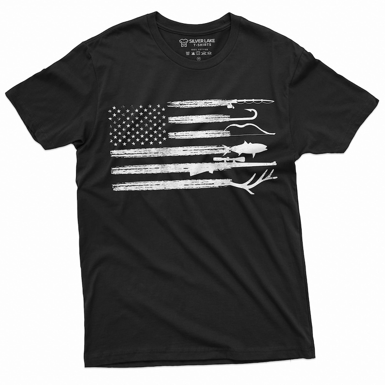 May include: Black t-shirt with a white distressed American flag design. The flag has various hunting and fishing items superimposed on it, including a rifle, a fish, a bow and arrow, and fishing rods.
