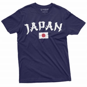 May include: A navy blue t-shirt with a white distressed graphic of the word "JAPAN" and the Japanese flag.