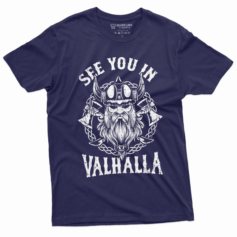 May include: Navy blue t-shirt with a white graphic of a Viking warrior and the text "SEE YOU IN VALHALLA". The design includes a Viking helmet, axes, and a beard. The shirt is from Silver Lake T-Shirts.