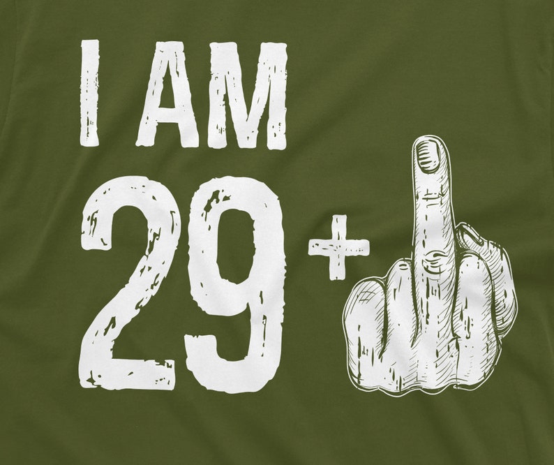 May include: Green t-shirt with white text that says "I AM 29+" and a white hand giving the middle finger.