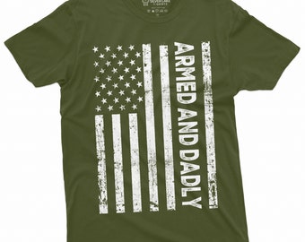 May include: A green t-shirt with a distressed American flag design and the text "ARMED AND DADLY" in white.