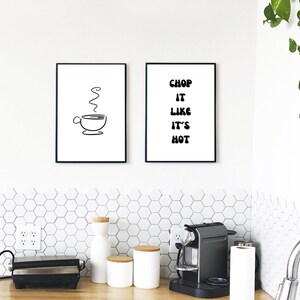 Könnte beinhalten: Zwei rechteckige Wandbilder in schwarzen Rahmen. Das linke Bild zeigt eine schwarze Strichzeichnung einer Kaffeetasse mit Dampf. Das rechte Bild zeigt den schwarzen Text "CHOP IT LIKE IT'S HOT" in einer fetten, abgerundeten Schrift.