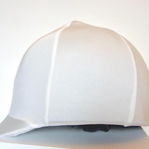 May include: White riding helmet liner with a smooth, seamless finish. The liner is designed to fit snugly inside a riding helmet and provides a comfortable and breathable layer.