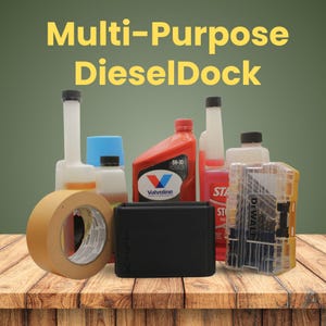 May include: A black rectangular Multi-Purpose DieselDock organizer container positioned in front of various automotive maintenance supplies, including a roll of tan masking tape, a DeWalt drill bit case, and several bottles of motor oil and fuel additives.
