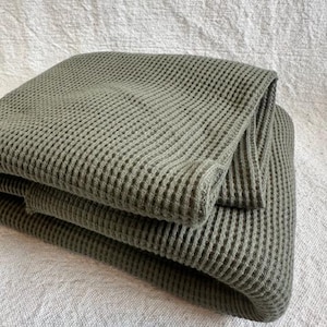 Premium cotton waffle knit fabric displayed flat to highlight its textured waffle pattern and heavyweight quality. This versatile thermal knit fabric is ideal for sewing comfortable apparel such as hoodies, joggers, sweaters, and cozy loungewear, as well as home items like blankets and throws. Made from cotton, it offers softness, durability, and breathability. Fabric is sold by the half yard and works well for year-round sewing projects.