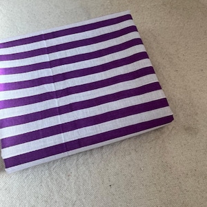 "Stacked Carnival Cotton fabric, showcasing its smooth, breathable texture and soft drape. Perfect for sewing t-shirts, dresses, and lounge sets. The natural cotton fibers provide a comfortable feel, making it a great choice for everyday wear and sustainable fashion."