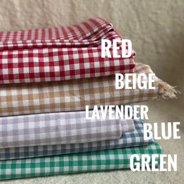 Può includere: Cinque campioni di tessuto gingham impilati in rosso, beige, lavanda, blu e verde.