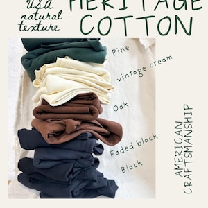 May include: A stack of folded cotton fabric in five colors: pine, vintage cream, oak, faded black, and black. Text reads: Milled in USA natural texture, HERITAGE COTTON, AMERICAN CRAFTSMANSHIP, and @iseefabric. The fabric has a ribbed texture.