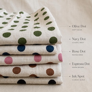 May include: A stack of five folded fabrics with a light beige base and polka dot patterns. The labels indicate: Olive Dot Soft Olive, Navy Dot Classic Navy, Rose Dot Muted Rose, Espresso Dot Warm Brown, and Ink Spot Classic Black.