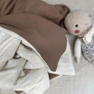 Folded heavy cotton rib knit fabric stacked in layers to illustrate softness, density, and texture. Perfect for cozy winter apparel and sewing projects, this image emphasizes the fabric’s weight, structure, and adaptability for crafting personalized wardrobe essentials.