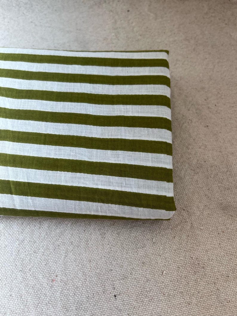"Folded Carnival Cotton fabric, emphasizing its crisp texture and timeless appeal. Perfect for creating tailored dresses, structured skirts, and stylish tops. The artisan prints offer durability while maintaining a soft, comfortable touch."