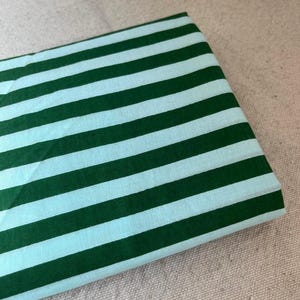 "Draped Carnival Cotton fabric, showcasing its lightweight structure and elegant drape. Ideal for sewing modern fashion projects, transitional seasonal wear, and home décor accents. The woven texture ensures breathability and comfort."