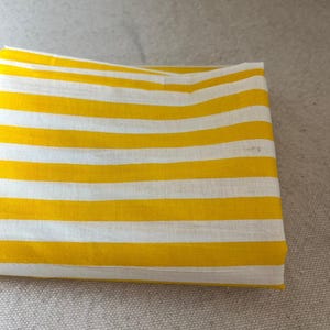 "Close-up of Carnival Cotton fabric, emphasizing its unique weave and airy structure. Great for crafting baby rompers, sleepwear, and casual apparel. The breathable cotton enhances airflow, ensuring a cozy and stylish touch for handmade garments."