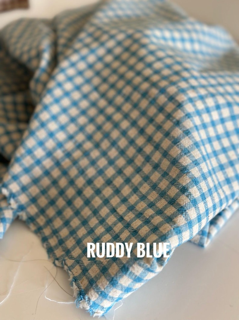 "Rolled gingham linen-cotton blend fabric, showcasing its lightweight, eco-friendly composition. Ideal for sewing summer outfits, aprons, and upholstery projects. The breathable weave enhances airflow, ensuring a cool and comfortable feel for everyday wear."
