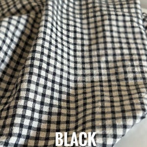 "Folded gingham linen-cotton blend fabric, highlighting its crisp structure and timeless checkered design. Perfect for creating vintage-inspired clothing, tote bags, and decorative pillows. The linen-cotton mix offers durability while maintaining a soft, comfortable touch."