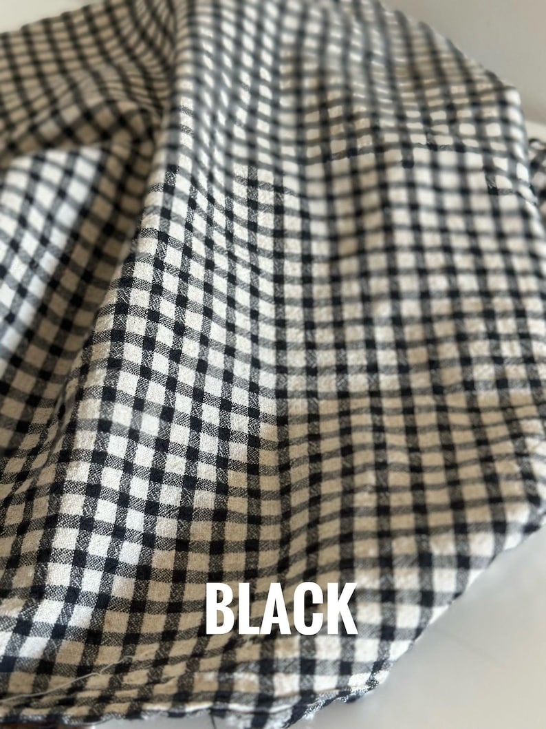 "Folded gingham linen-cotton blend fabric, highlighting its crisp structure and timeless checkered design. Perfect for creating vintage-inspired clothing, tote bags, and decorative pillows. The linen-cotton mix offers durability while maintaining a soft, comfortable touch."