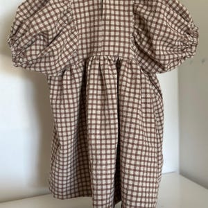 "Rolled gingham linen-cotton blend fabric, emphasizing its lightweight, eco-friendly composition. Perfect for sewing summer outfits, aprons, and upholstery projects. The breathable weave enhances airflow, ensuring a cool and comfortable feel for everyday wear."