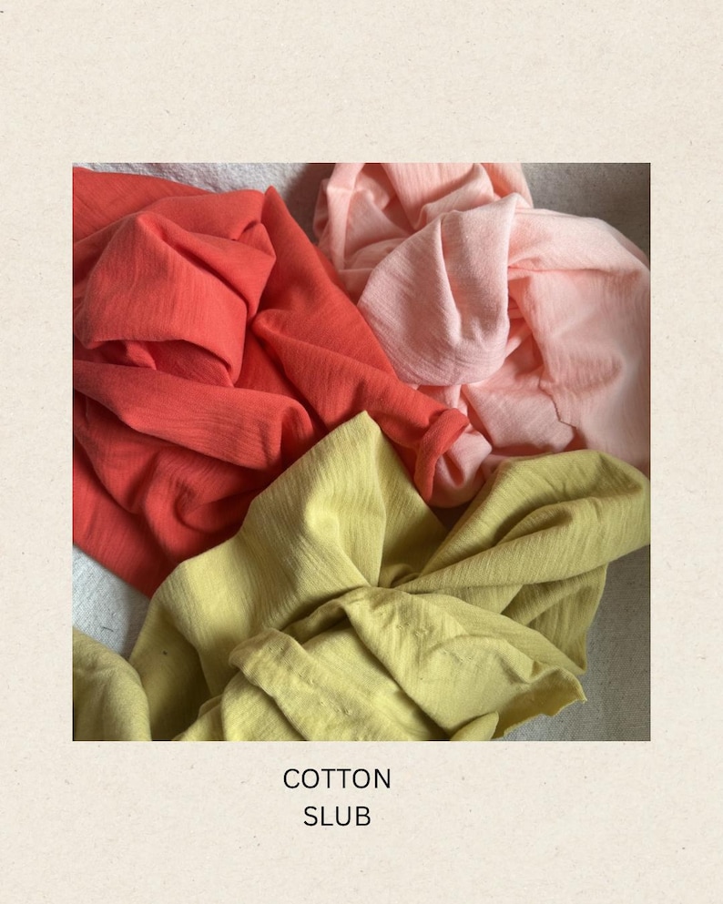 May include: Close-up of four swatches of cotton fabric in shades of coral, peach, and yellow-green. The fabric is textured and draped, with the words "COTTON SLUB" printed at the bottom.