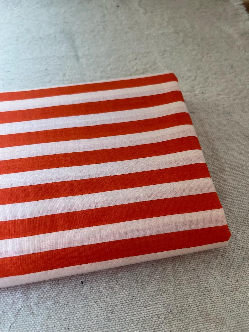 "Rolled Carnival Cotton fabric, showcasing its eco-friendly composition and smooth weave. Ideal for sewing elegant apparel, lightweight scarves, and decorative home textiles. The breathable fabric enhances airflow, ensuring a cool and comfortable feel."