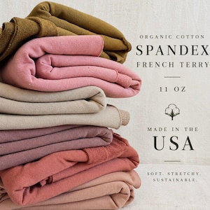 May include: A stack of folded organic cotton spandex French terry fabric in various shades of olive, pink, beige, mauve, and terracotta. The text reads: ORGANIC COTTON SPANDEX FRENCH TERRY 11 OZ MADE IN THE USA SOFT. STRETCHY. SUSTAINABLE.