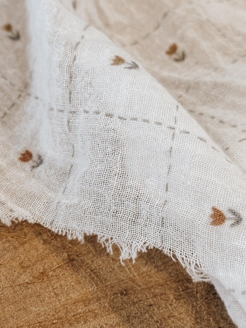 Airy Salt Air cotton gauze fabric presented with gentle folds to highlight its lightweight feel and soft texture. This double gauze cotton fabric features a breathable weave and slightly crinkled surface, perfect for relaxed garments and baby-friendly projects. Ideal for dresses, tops, swaddles, and scarves, this fabric combines comfort with a natural, coastal-inspired look. Its soft drape and neutral tone make it a versatile choice for modern sewing designs.