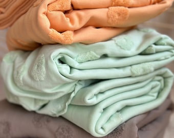 Tejido de jersey jacquard de algodón orgánico por media yarda. Tejido de punto suave y texturizado para proyectos de costura sostenibles.