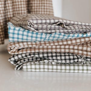"Close-up of gingham linen-cotton blend fabric, showcasing its soft, breathable texture and classic check pattern. Ideal for sewing apparel, home décor, and handmade crafts. The eco-friendly blend combines linen’s durability with cotton’s softness, making it perfect for lightweight garments and stylish accessories."