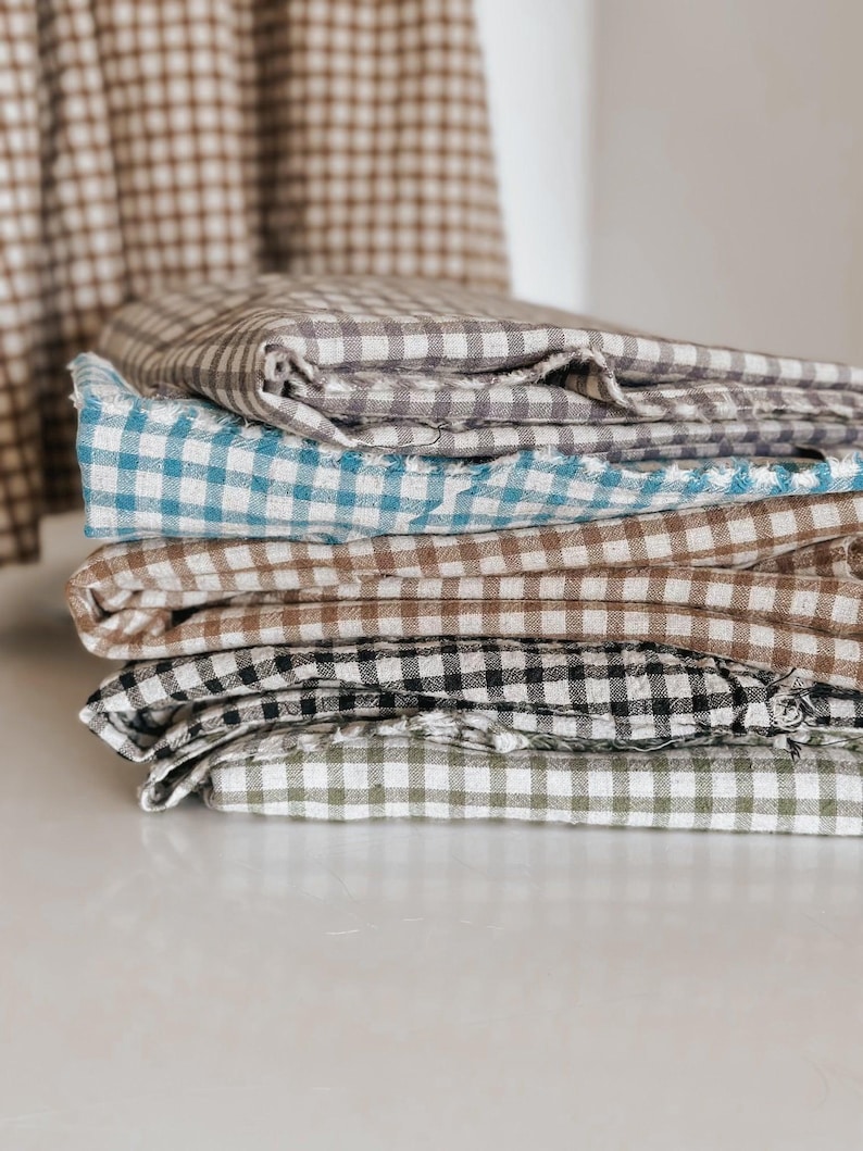 "Close-up of gingham linen-cotton blend fabric, showcasing its soft, breathable texture and classic check pattern. Ideal for sewing apparel, home décor, and handmade crafts. The eco-friendly blend combines linen’s durability with cotton’s softness, making it perfect for lightweight garments and stylish accessories."