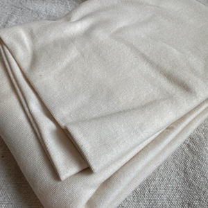 Close-up image of 1x1 rib knit fabric made from 100% USA-milled cotton. The photo shows fine rib texture and soft natural stretch, highlighting the breathable weave and smooth hand feel. Ideal for sewing ribbed tees, cuffs, neckbands, and loungewear. The even rib pattern and premium cotton fibers make this knit perfect for sustainable handmade apparel and sewing projects requiring comfort and durability.