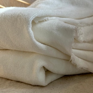 "Rolled organic cotton sponge knit terry fabric, showcasing its plush, moisture-wicking properties. Great for sewing layering pieces, baby apparel, and cozy garments. The sponge knit texture enhances breathability, ensuring a soft and comfortable feel for everyday wear."
