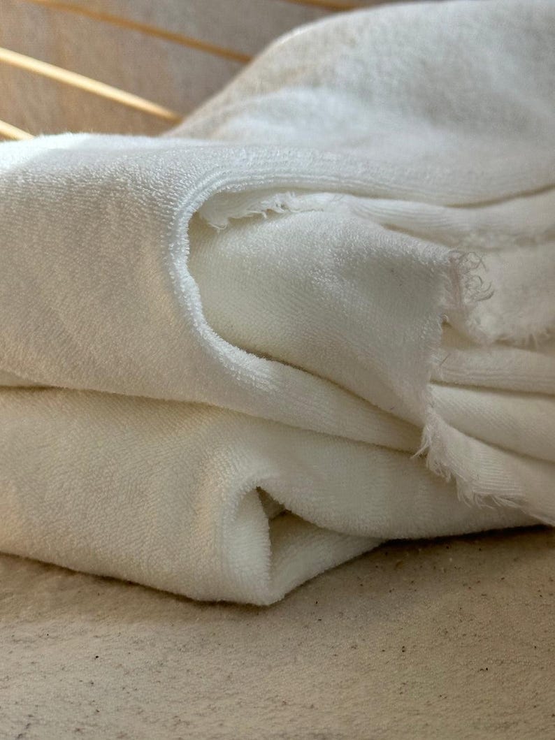 "Rolled organic cotton sponge knit terry fabric, showcasing its plush, moisture-wicking properties. Great for sewing layering pieces, baby apparel, and cozy garments. The sponge knit texture enhances breathability, ensuring a soft and comfortable feel for everyday wear."
