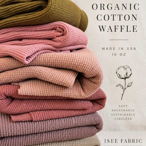 May include: A stack of folded organic cotton waffle fabric in various shades of olive, pink, rose, and beige. Text reads: ORGANIC COTTON WAFFLE, MADE IN USA, 10 OZ, SOFT BREATHABLE SUSTAINABLE TIMELESS, ISEE FABRIC, FABRIC FOR A KINDER TOMORROW.