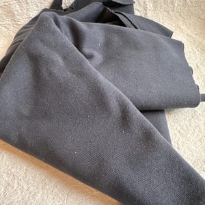 Image showing folded 1x1 cotton rib knit fabric to highlight flexibility and natural drape. The photo focuses on the ribbed texture, breathable cotton fibers, and soft matte surface. Proudly milled in the USA, this 100% cotton rib knit is ideal for sewing tops, trims, and cuffs. The detailed image emphasizes quality construction, tight weave, and stretch structure that enhances comfort and durability for handmade apparel.