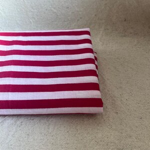 "Folded Carnival Cotton fabric, emphasizing its crisp texture and semi-opaque finish. Perfect for creating tailored dresses, structured skirts, and stylish tops. The handcrafted prints add a unique touch, making it ideal for artisan sewing projects."