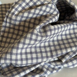 "Close-up of gingham linen-cotton blend fabric, highlighting its soft, breathable texture and timeless checkered design. Ideal for sewing apparel, home décor, and handmade crafts. The eco-friendly blend combines linen’s durability with cotton’s softness, making it perfect for lightweight garments and stylish accessories."