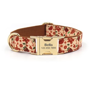 May include: A brown and cream dog collar with a gold buckle. The collar has a festive gingerbread pattern and the text "Bella 123 456 7890" engraved on the buckle.